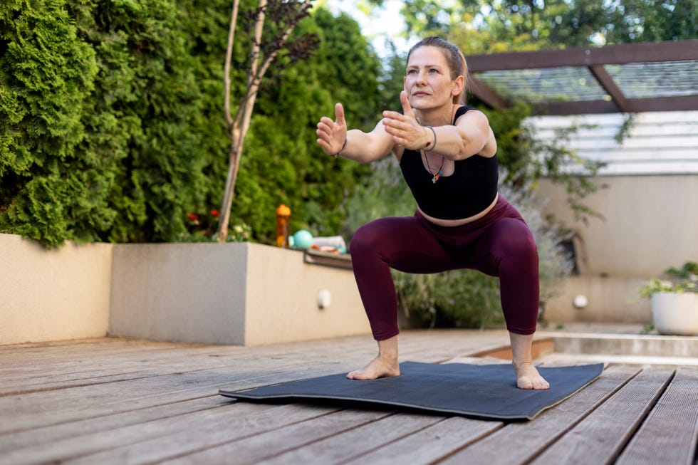 woman exercising on her patio. about 45 years old, caucasian redhead.