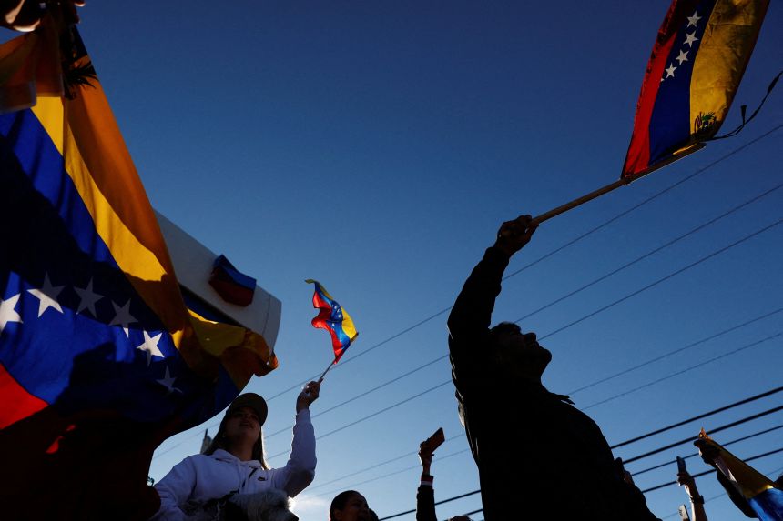 People holding Venezuelan flags react to the news after US President Donald Trump said the has struck Venezuela and captured its President Nicolas Maduro in Doral, Florida, on January 3.