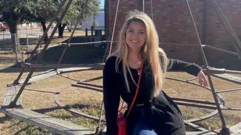 Adrienne Martin Adrienne Martin sits on a bench outside while wearing a black sweater