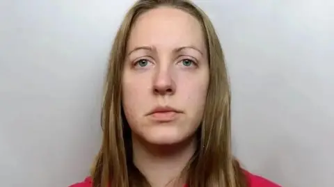 Cheshire Police Police custody image of Lucy Letby with long blond hair and red top.