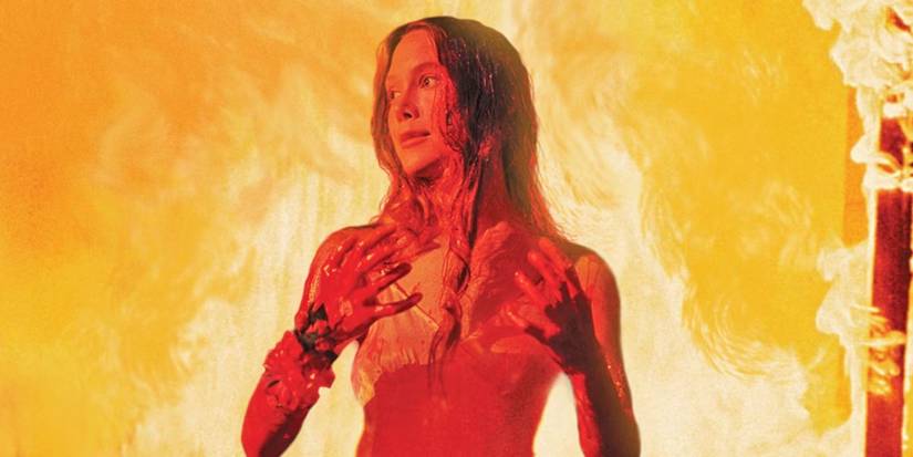 Sissy Spacek as Carrie covered in blood with a fire burning behind her in Carrie.