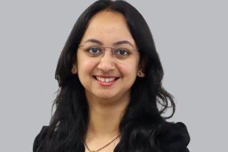 Woman with black top and glasses smiles at camera