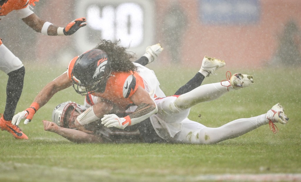 Denver Broncos safety Talanoa Hufanga tackling Patriots quarterback Drake Maye.