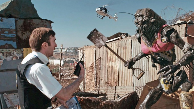 Wikus van de Merwe speaking with a shovel-wielding alien in 
