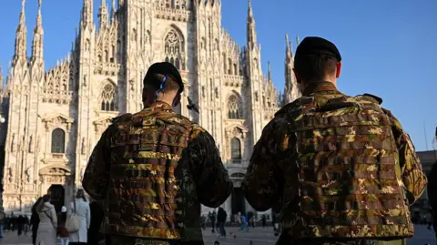 Piero CRUCIATTI/AFP Italian military stand guard outside a cathedral in Milan