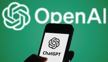 Smartphone displaying ChatGPT logo held in front of white OpenAI logo on green background