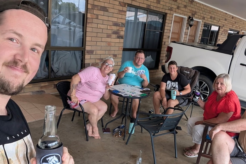 Group of people crowd around table