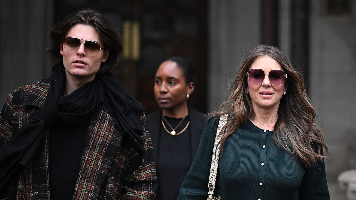 Elizabeth Hurley walking alongside her son outside London's High Court.