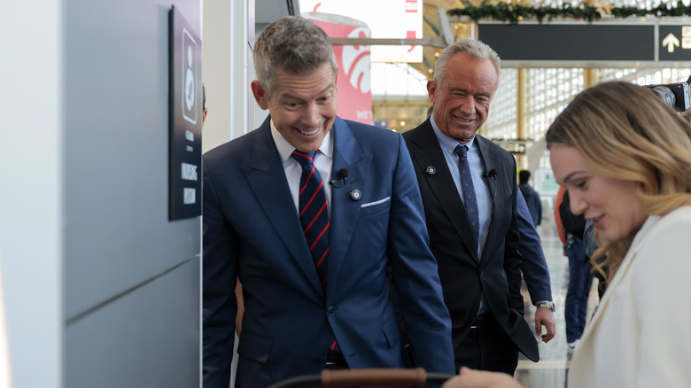 A woman shows her baby to Transportation Secretary Sean Duffy and HHS Secretary RFK Jr.
