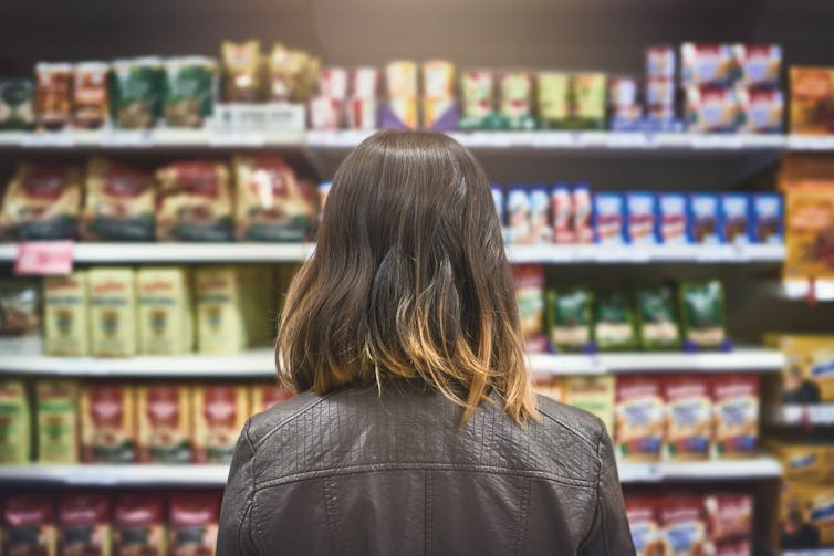 Person standing in front of grocery store aisle