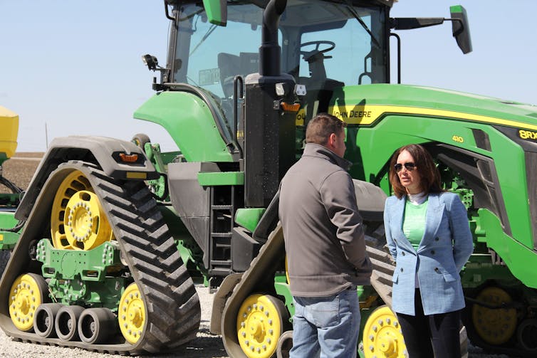 US agriculture secretary, Brooke Rollins, talks to a pig farmer in Iowa in front of his tractor, March 2025.
