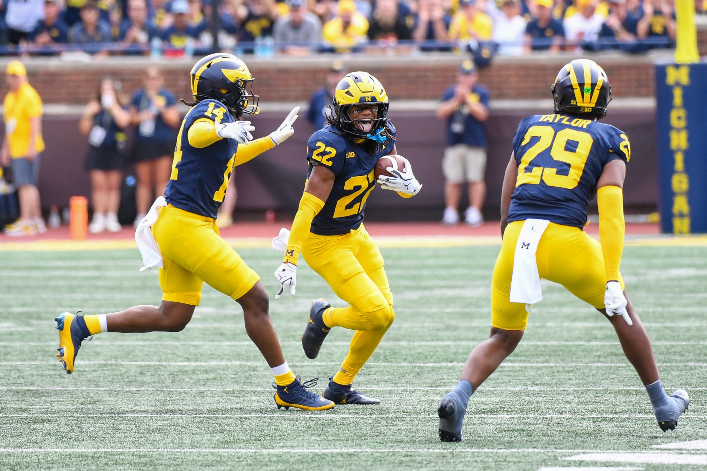 ANN ARBOR, MICHIGAN - SEPTEMBER 13: (L-R) Jordan Young #14, Elijah Dotson #22, and Chase Taylor #29 of the Michigan Wolverines react after an interception during the second half of a college football game against the Central Michigan Chippewas at Michigan Stadium on September 13, 2025 in Ann Arbor, Michigan. The Michigan Wolverines won the game 63-3. (Photo by Aaron J. Thornton/Getty Images)