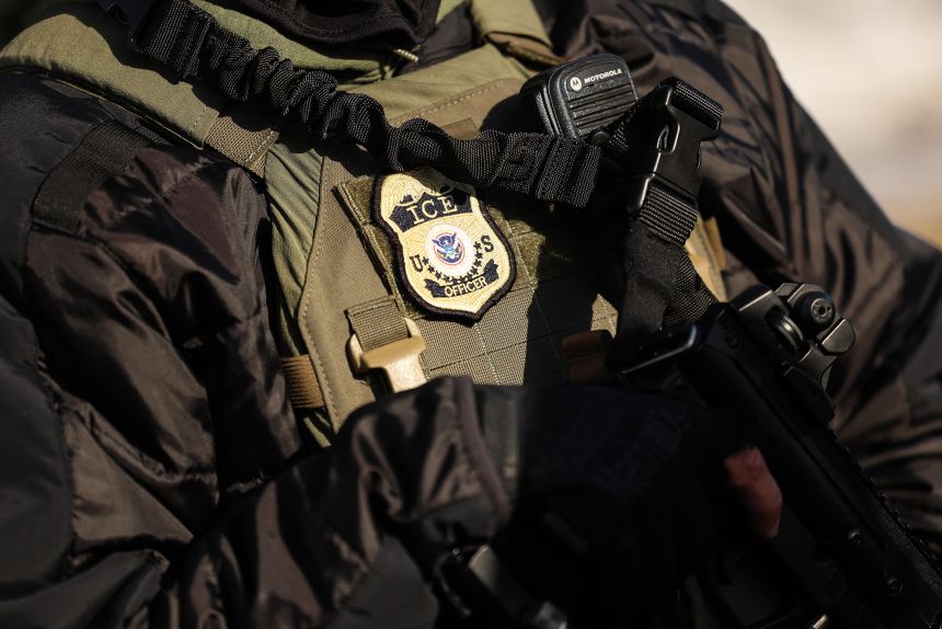 A federal officer monitors the scene as protesters gather near the Bishop Henry Whipple Federal Building in Minneapolis, Minnesota, on January 9.