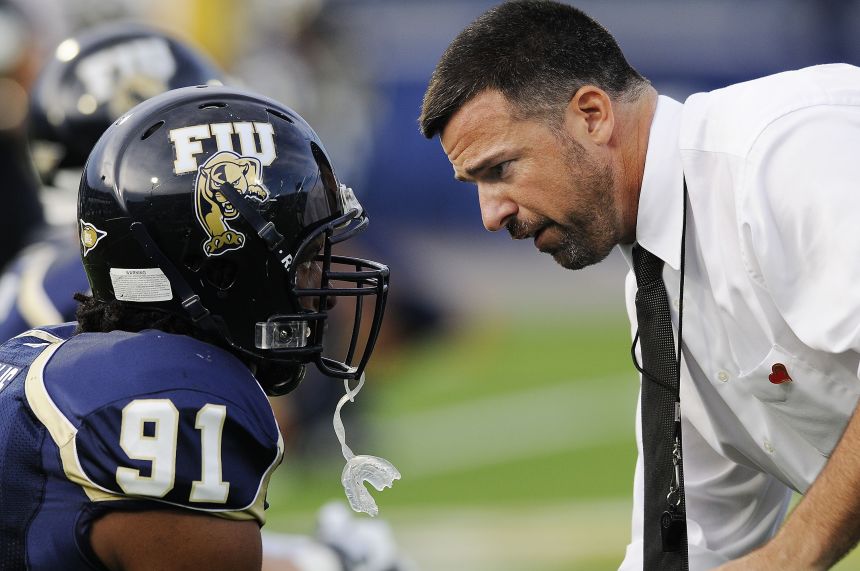 Mario Cristobal, as head coach of Florida International, speaks with linebacker Armond Willis before a game in 2008.
