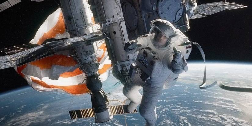 Dr. Stone (Sandra Bullock) is tangled in a parachute cord. She holds a broken tether as she watches her colleague float away