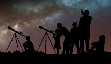 A group of people look up at the night sky through telescopes.