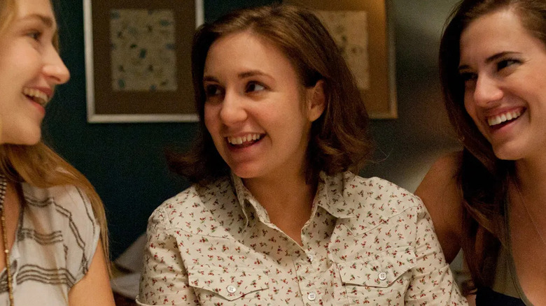 Lena Dunham as Hannah Horvath smiling at Jemima Kirke as Jessa next to Allison Williams as Marnie in Girls