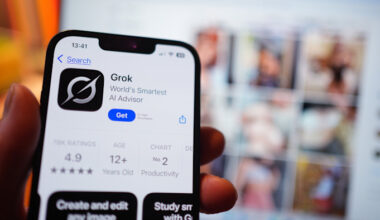 The Grok app page is shown on an iPhone in the App Store, with blurred X (formerly Twitter) search results visible on a laptop screen in the background.
