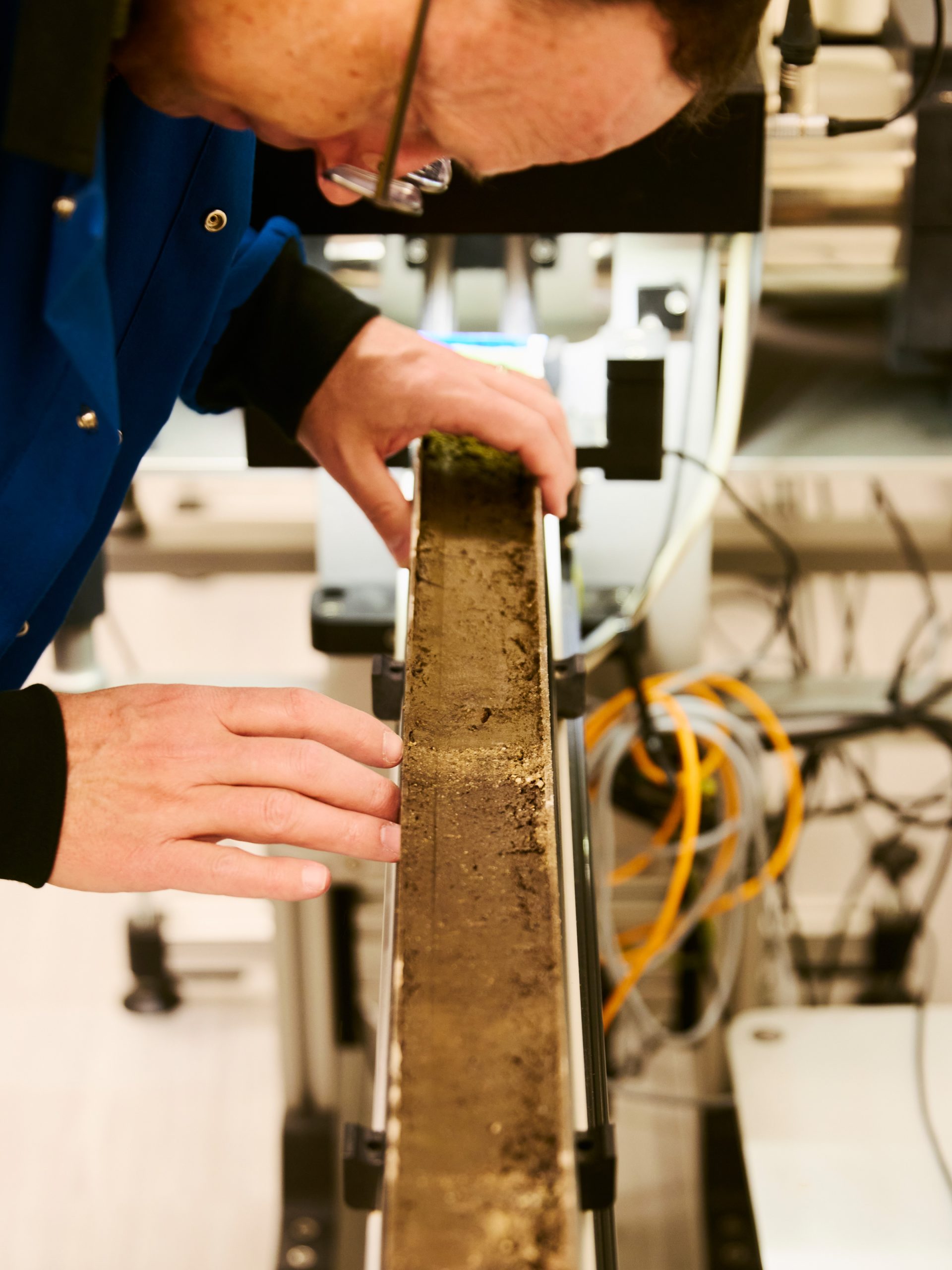 A lake sediment core from the Bighorn Mountains is analyzed with a Geotek core logger, an instrument that measures sediment density and elemental concentrations to reveal environmental conditions preserved in the mud.