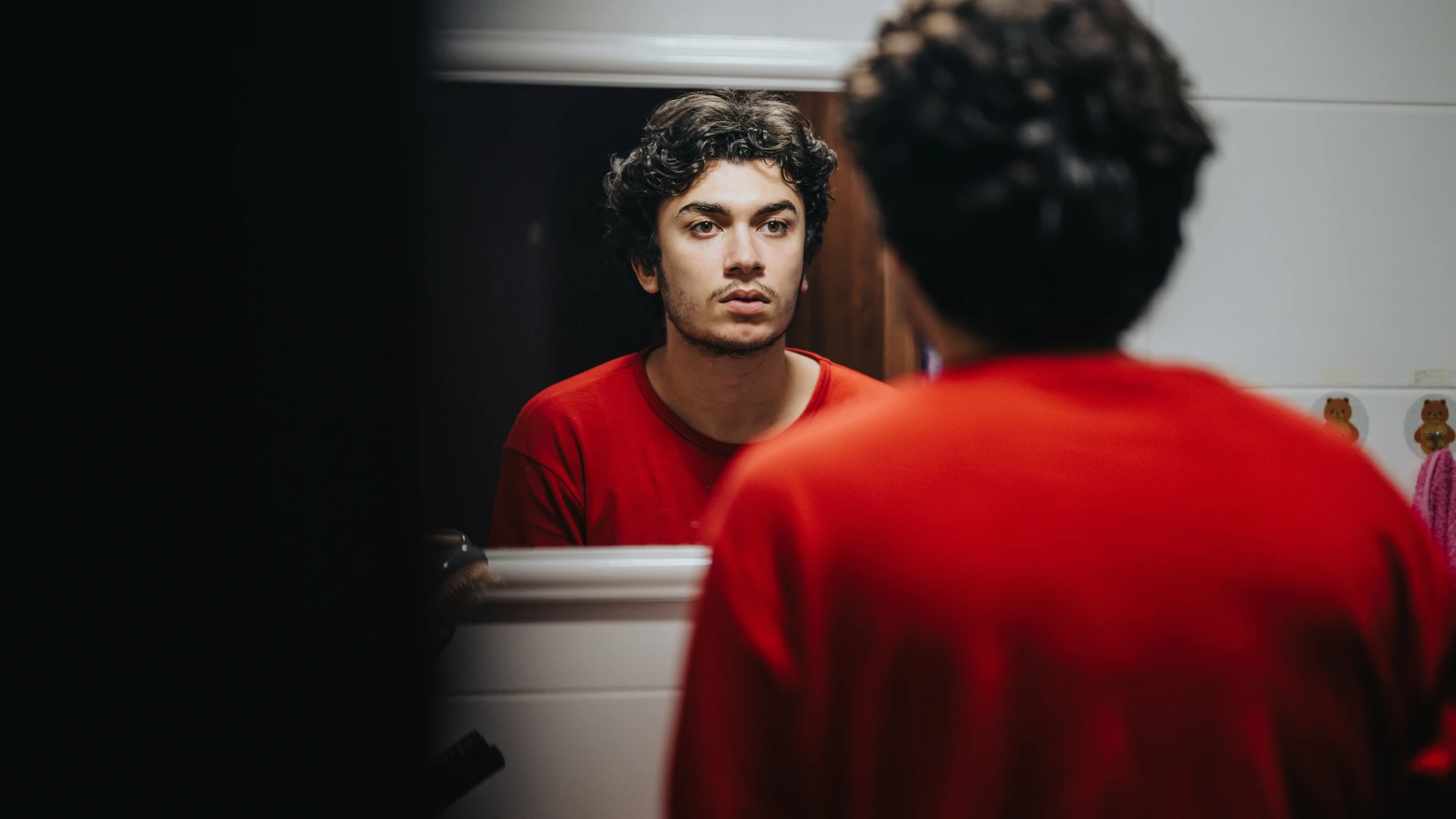 man with a lack of hygiene products looking in the mirror