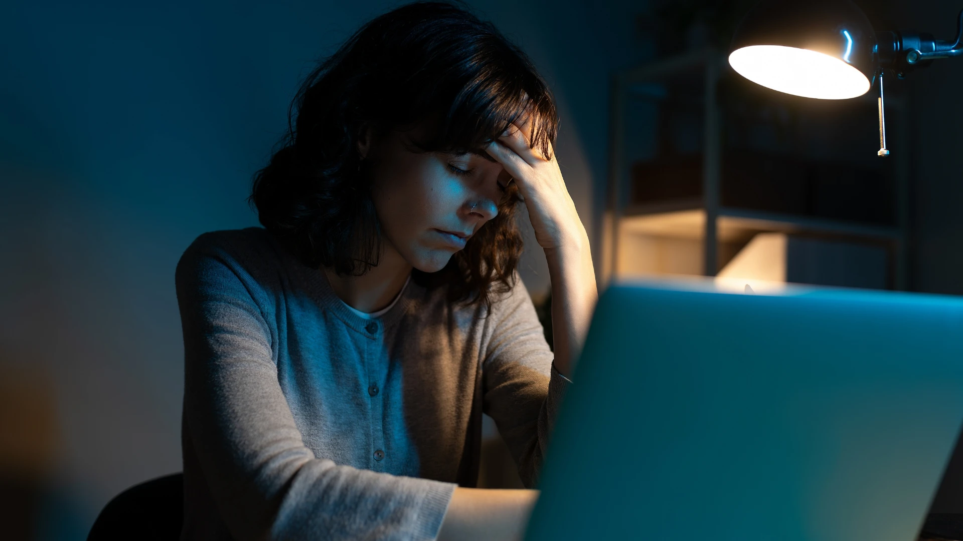 woman sitting in dark lighting at home