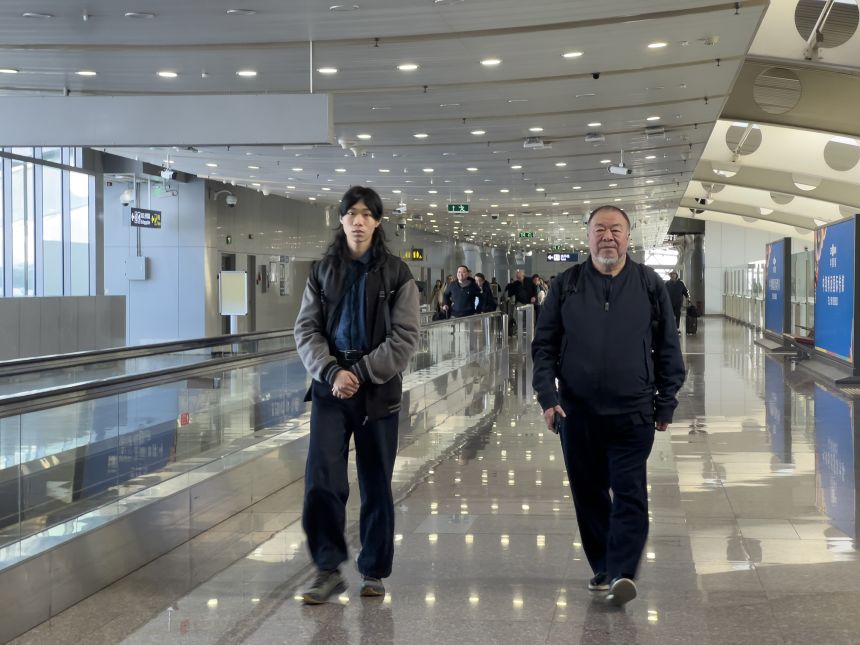 The artist flew into Beijing Capital International Airport with his 17-year-old son. This photo was captured on their way out of the airport.