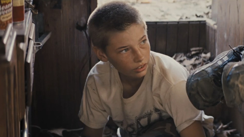 Jacob Lofland's Neckbone looks off to his left as he sits in the inside of a boat in Mud