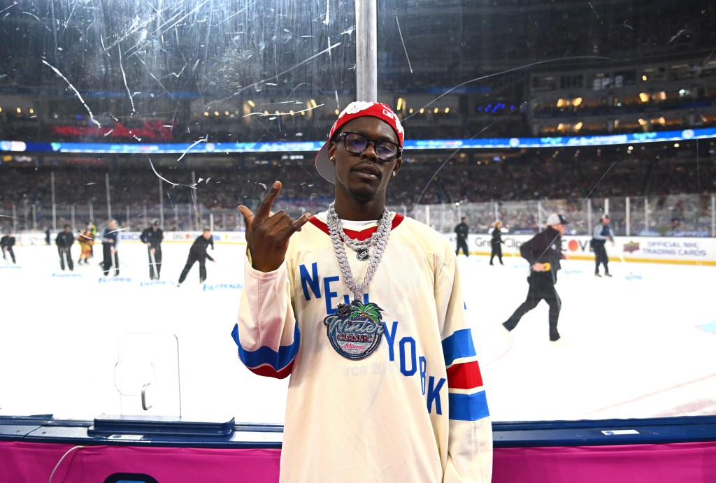 Jazz Chisolm Jr. stands by the glass during the 2026 Discover NHL Winter Classic game.