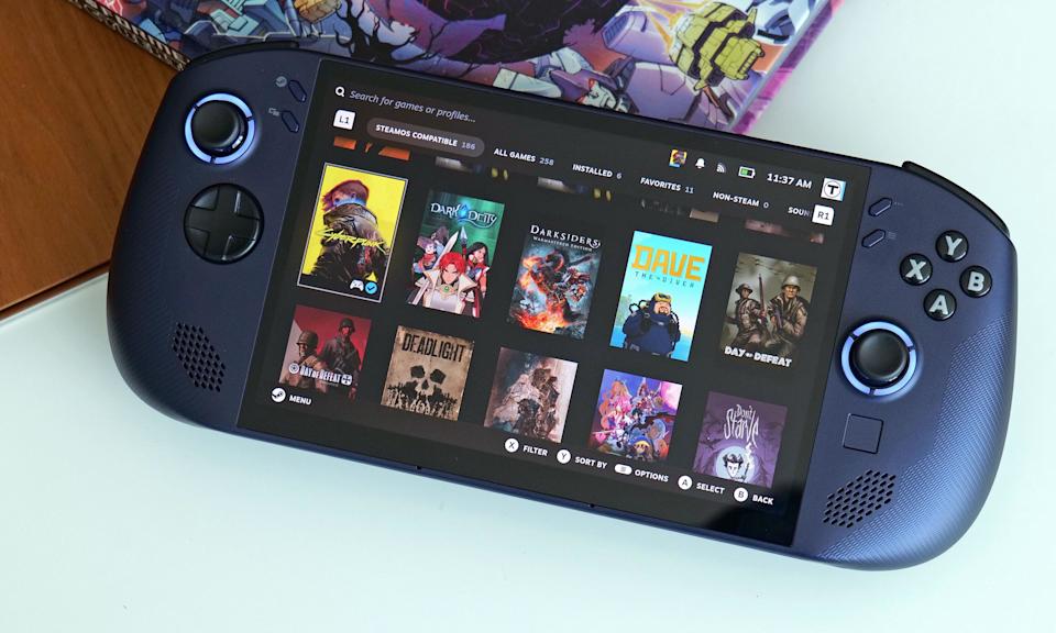 The Lenovo Legion Go S sits on an opaque glass table with a comic book behind it. 