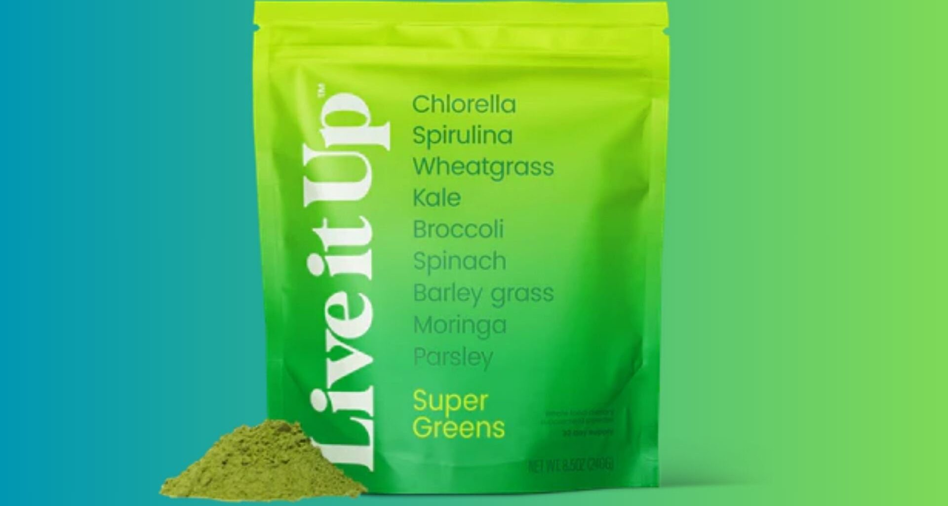 A green and yellow pouch labeled "Live it Up Super Greens" stands upright with a pile of green powder beside it. Ingredients like chlorella, spirulina, kale, and spinach are listed on the front of the pouch.