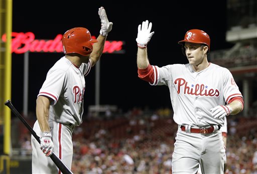 Phillies star Chase Utley, right, is congratulated after hitting a two-run home run in the eighth inning of a game against the Cincinnati Reds, Monday, April 15, 2013, in Cincinnati. (AP file photo)