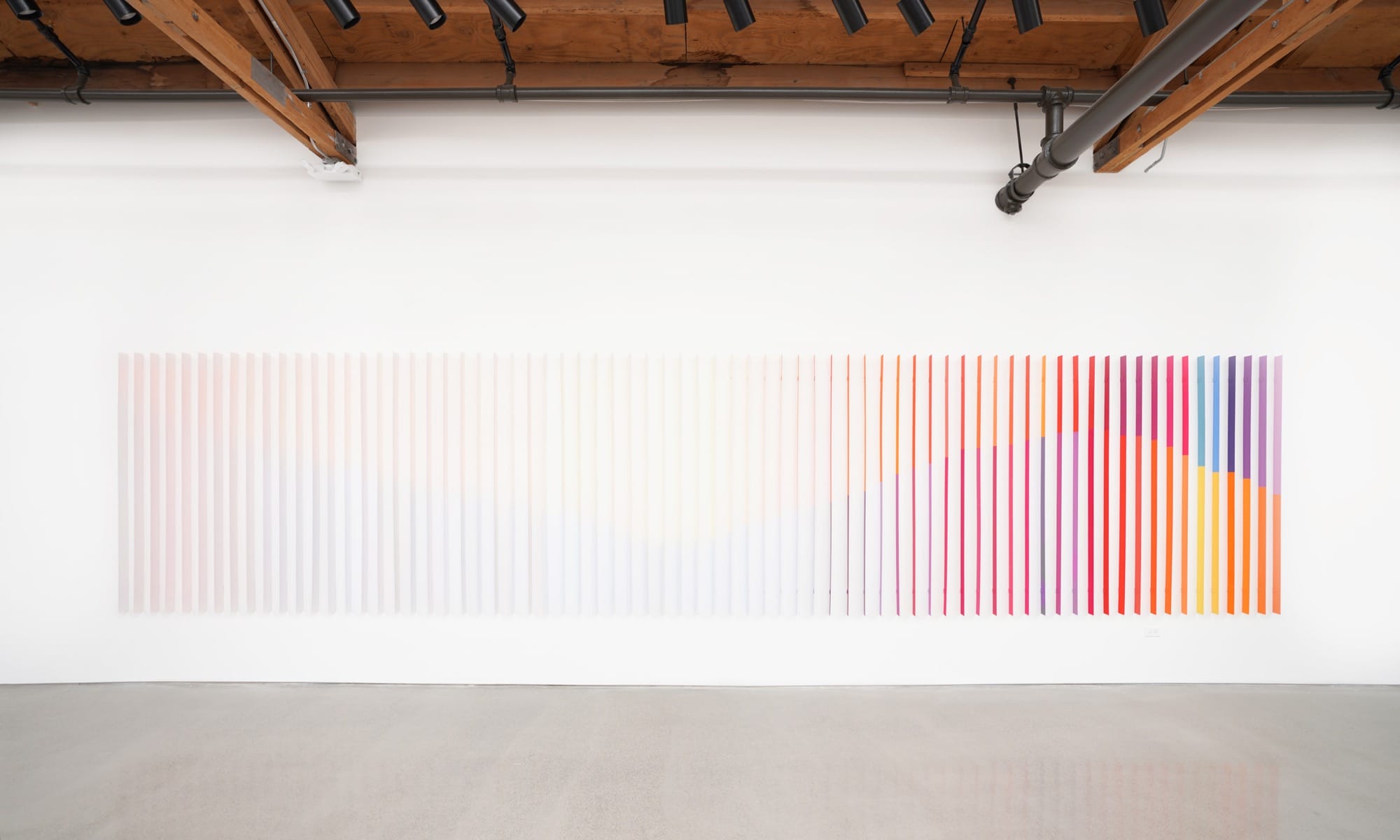 an installation by Luftwerk of a light gradient of thin, vertical strips on a gallery wall