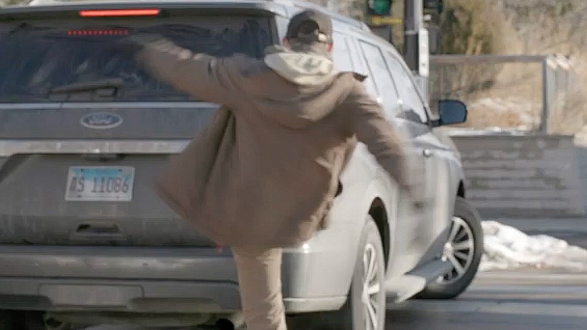 A man kicking a car.