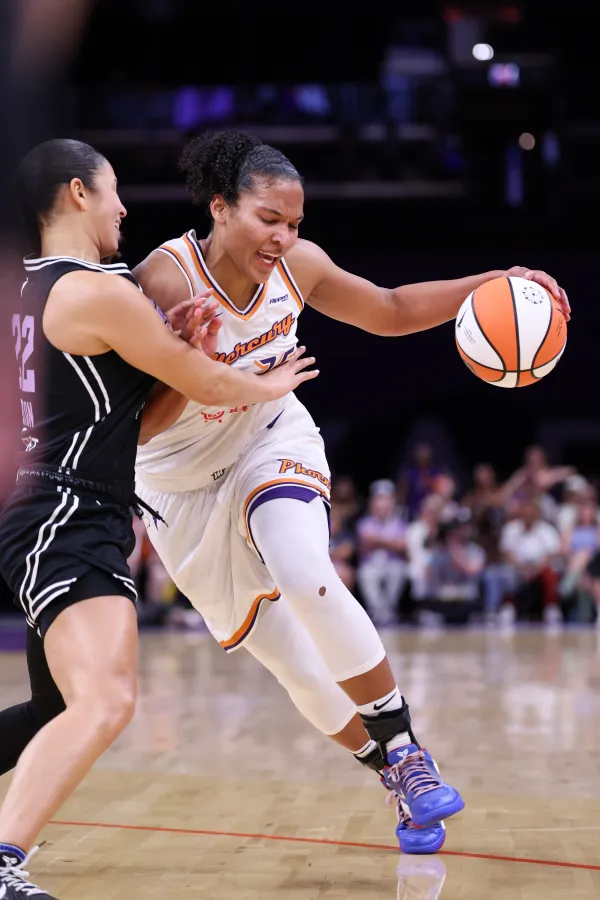 PHOENIX, ARIZONA - MAY 11: Alyssa Thomas #25 of the Phoenix Mercury dribbles the ball while Veronica Burton #22 of the Golden State Valkyries attempts to block her during the second quarter at PHX Arena on May 11, 2025 in Phoenix, Arizona