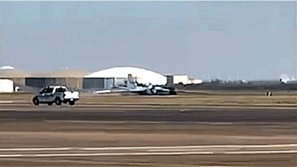 A NASA aircraft performing a gear-up landing on an airport runway.