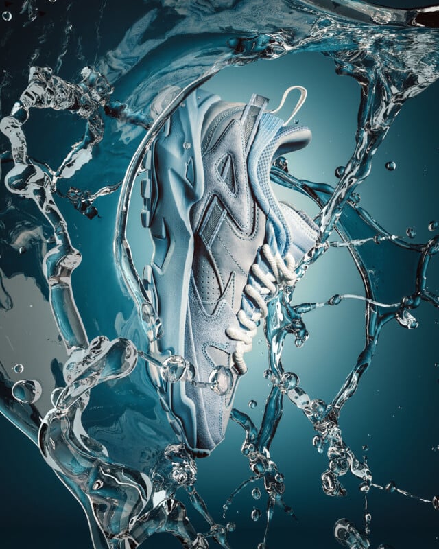 A stylish light blue sneaker is suspended mid-air, dramatically surrounded by splashing water, set against a teal background, highlighting the shoe’s texture and dynamic movement.