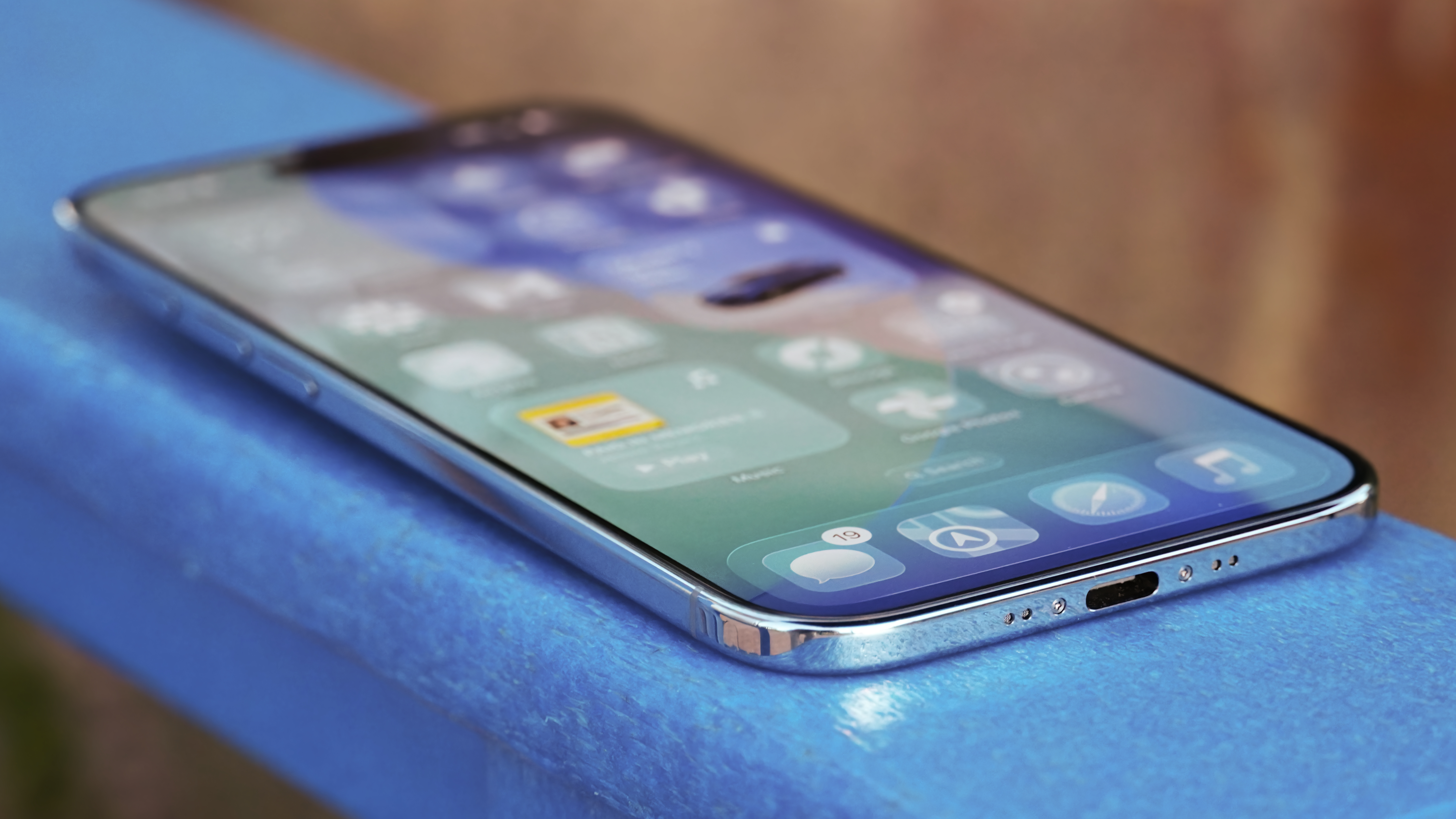 The display of an iPhone Air in Sky Blue on a blue chair.