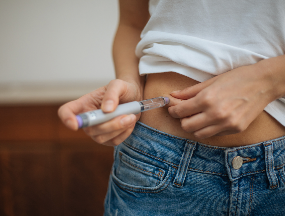 woman injects insulin in stomach