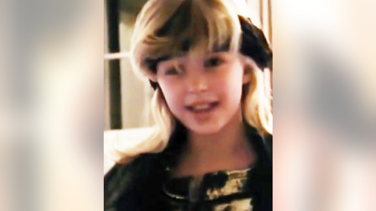 A young Paris Hilton wearing black with a matching headband.