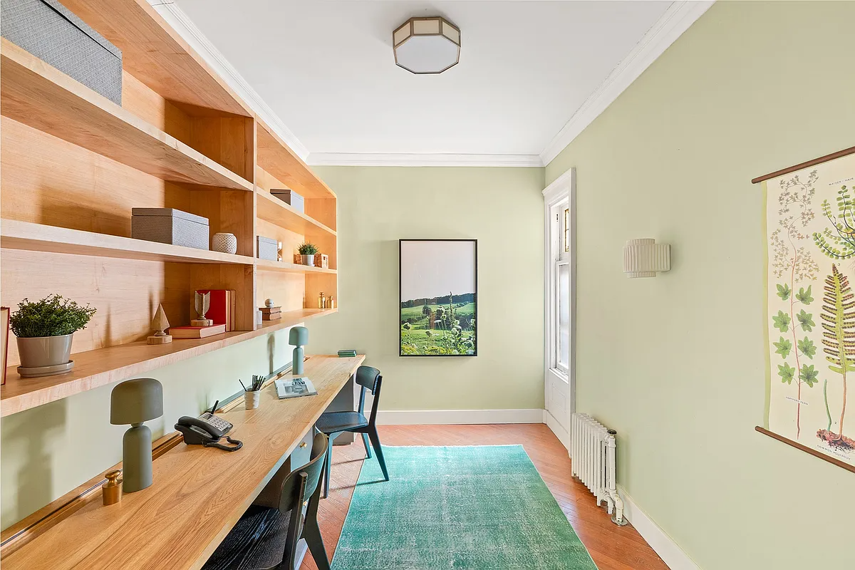 bedroom set up as an office with narrow wood counter, one window