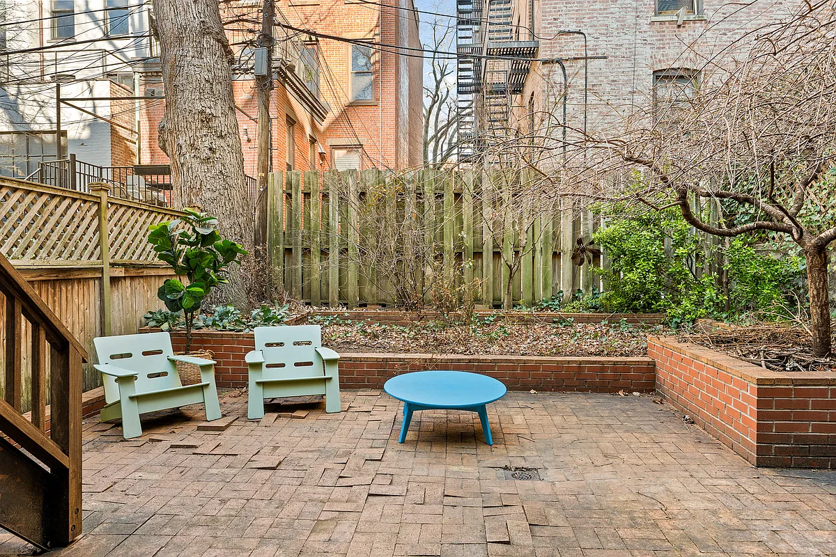 rear yard with a brick paved patio and planting beds