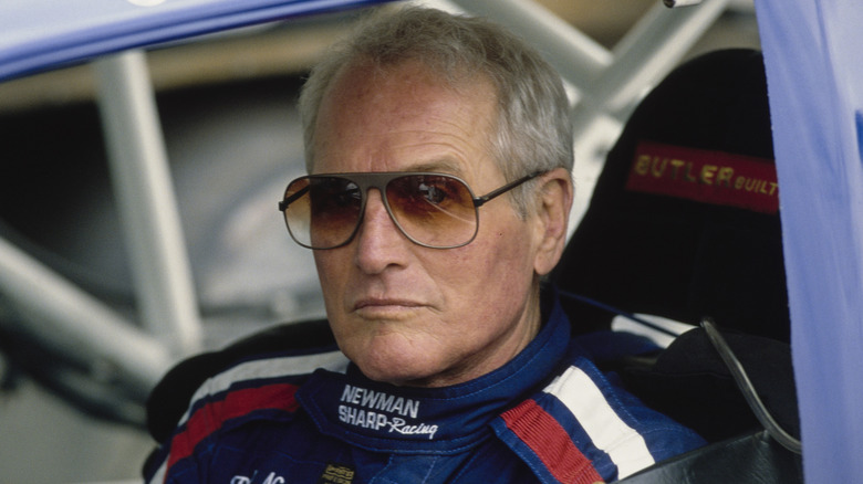 Actor and racing driver Paul Newman (1925 - 2008), looks on from the cockpit of the #75 Newman/Sharp Racing Oldsmobile Cutlass Supreme Buick V6 before the start of the Sports Car Club of America (SCCA) Trans-Am Series Iceberg Grand Prix race on 10th March 1990 at the Phoenix street course in Phoenix, Arizona, United States.