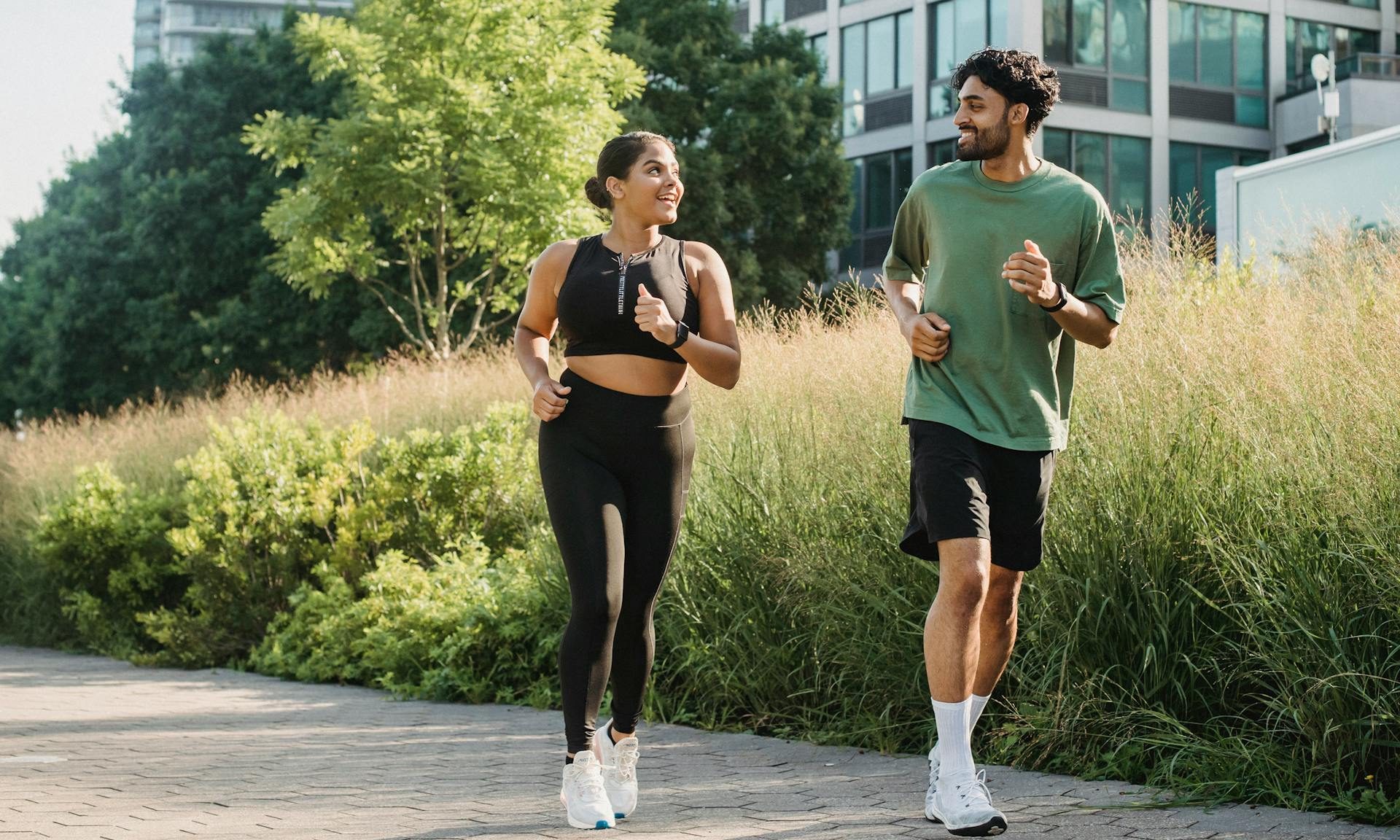 Man and woman running together runner high happy smile outdoors exercise workout