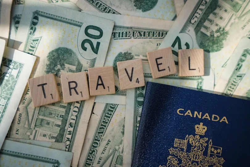travel written on scrabble tils with passport and cash