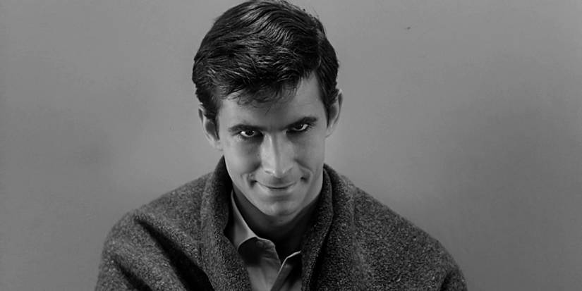 Anthony Perkins smirking evilly and looking at the camera in Psycho.