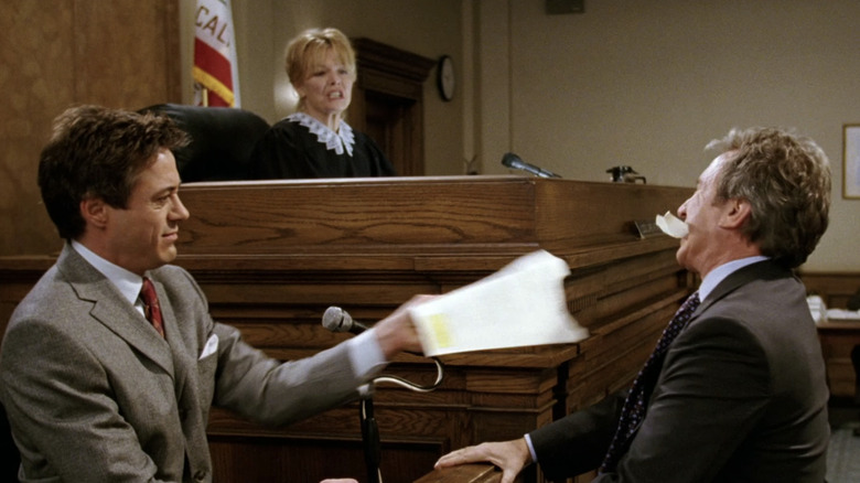 Robert Downey Jr's Dr Marcus Kozak pulls a piece of paper from the mouth of Tim Allen's David Douglas in The Shaggy Dog