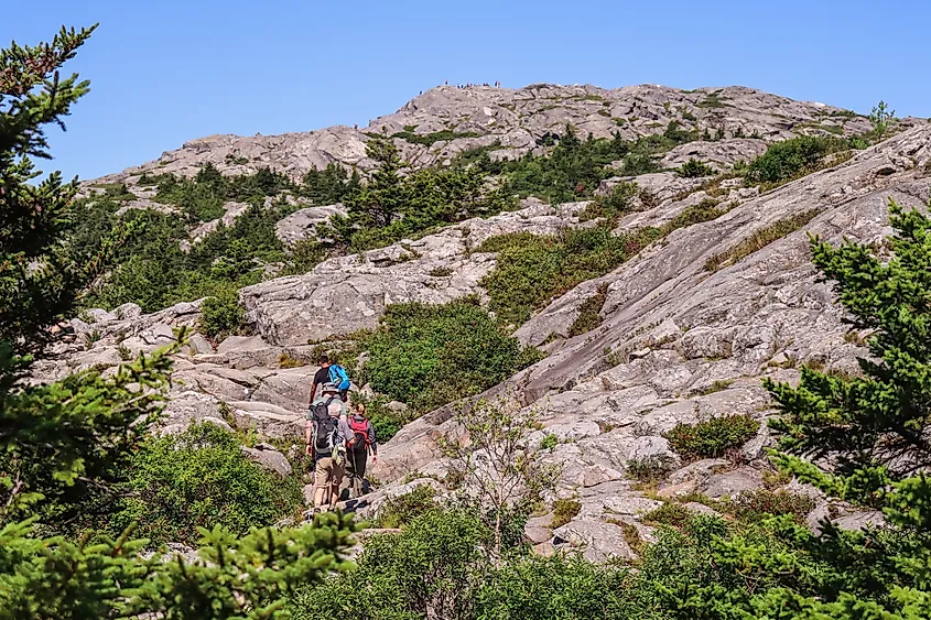 Small group of hikers ascending Mount Monadnock at Monadnock State Park in New Hampshire