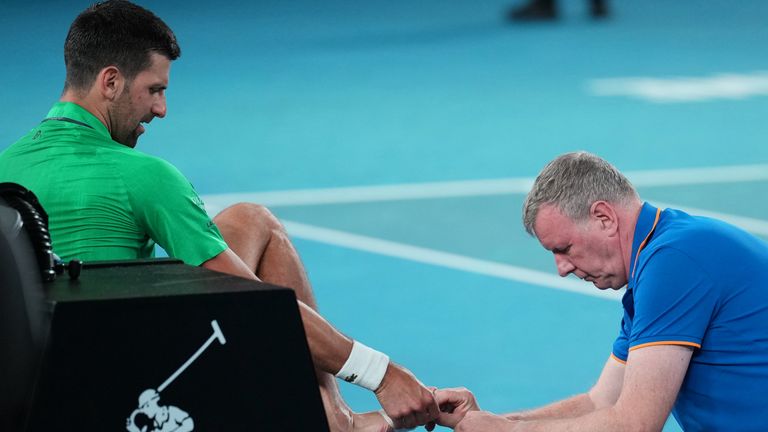 Novak Djokovic of Serbia receives treatment to a foot injury during his third round match against Botic van de Zandschulp of the Netherlands