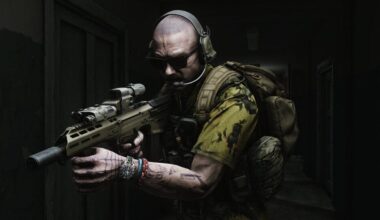 A man carries a rifle down a dark hallway.