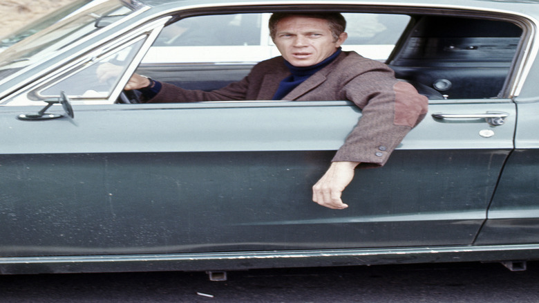 American actor Steve McQueen (1930 - 1980) (as Frank Bullitt) hangs his arm out the driverside window of a car in a scene from 'Bullitt' (directed by Peter Yates), California, 1968.